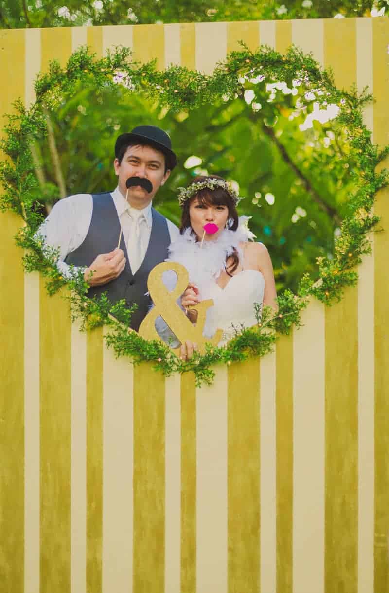 DIY whimsical wedding in Hawaii with photo booth backdrops heart yellow stripes