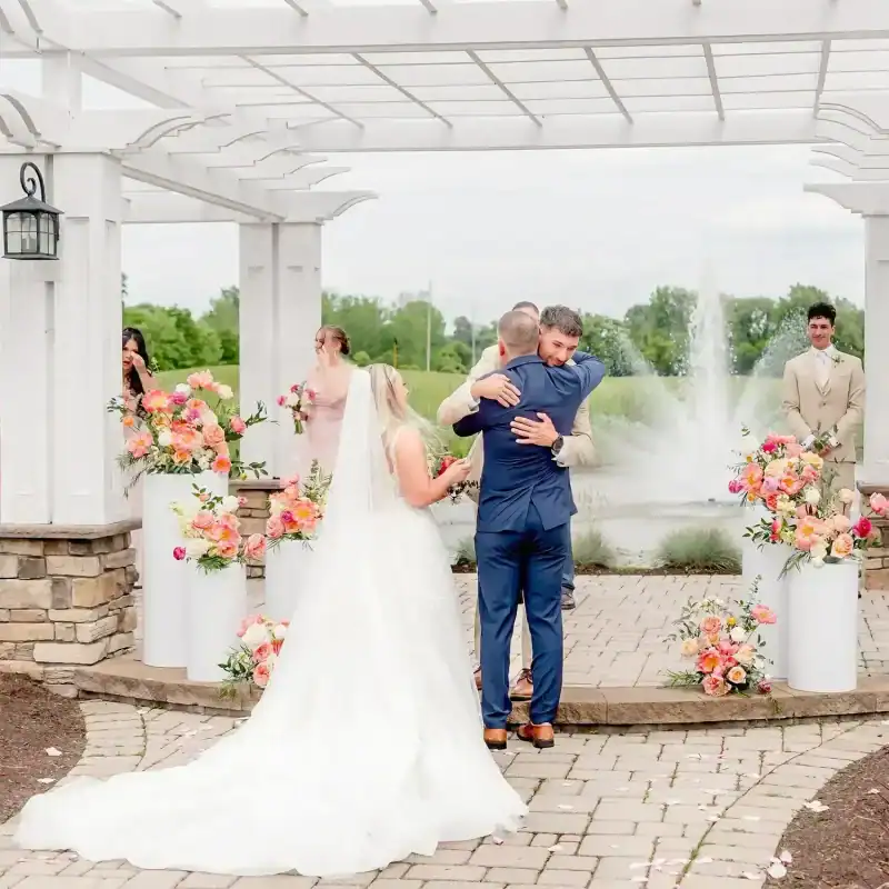 father of the bride hugs groom